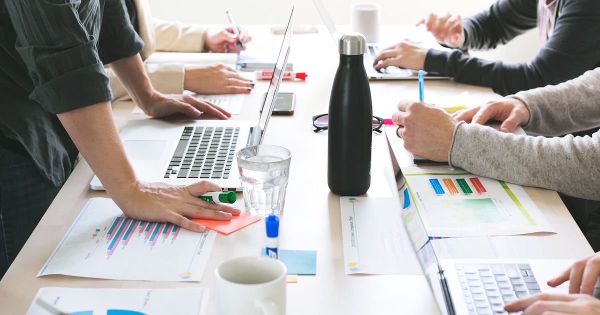 Collaborateurs réunis autour d'une table de travail, échangeant idées et analyses dans une démarche collective de diagnostic d'entreprise.
